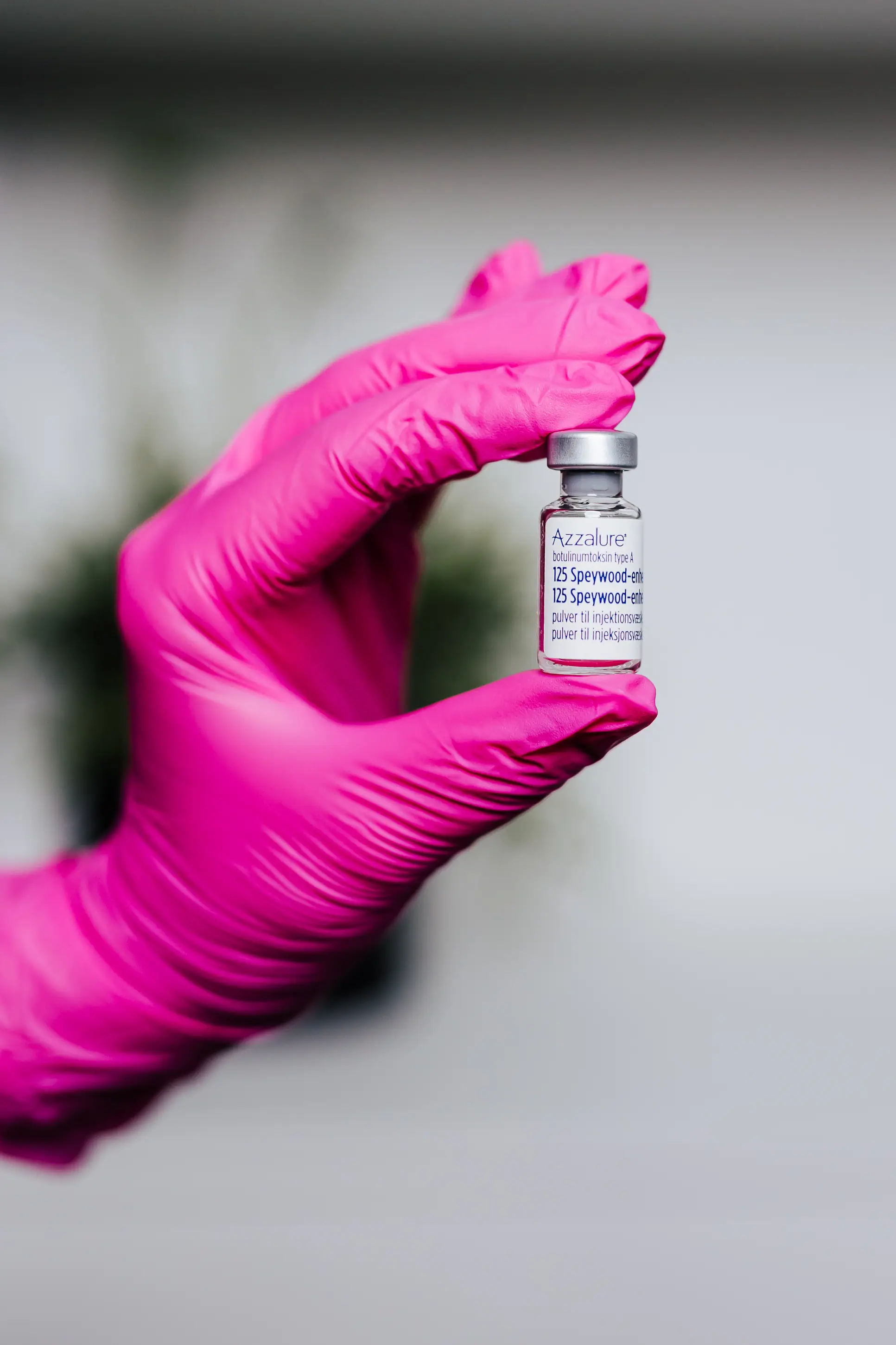 Hætteglas med botox holdt i en pink handske hos MediSkin