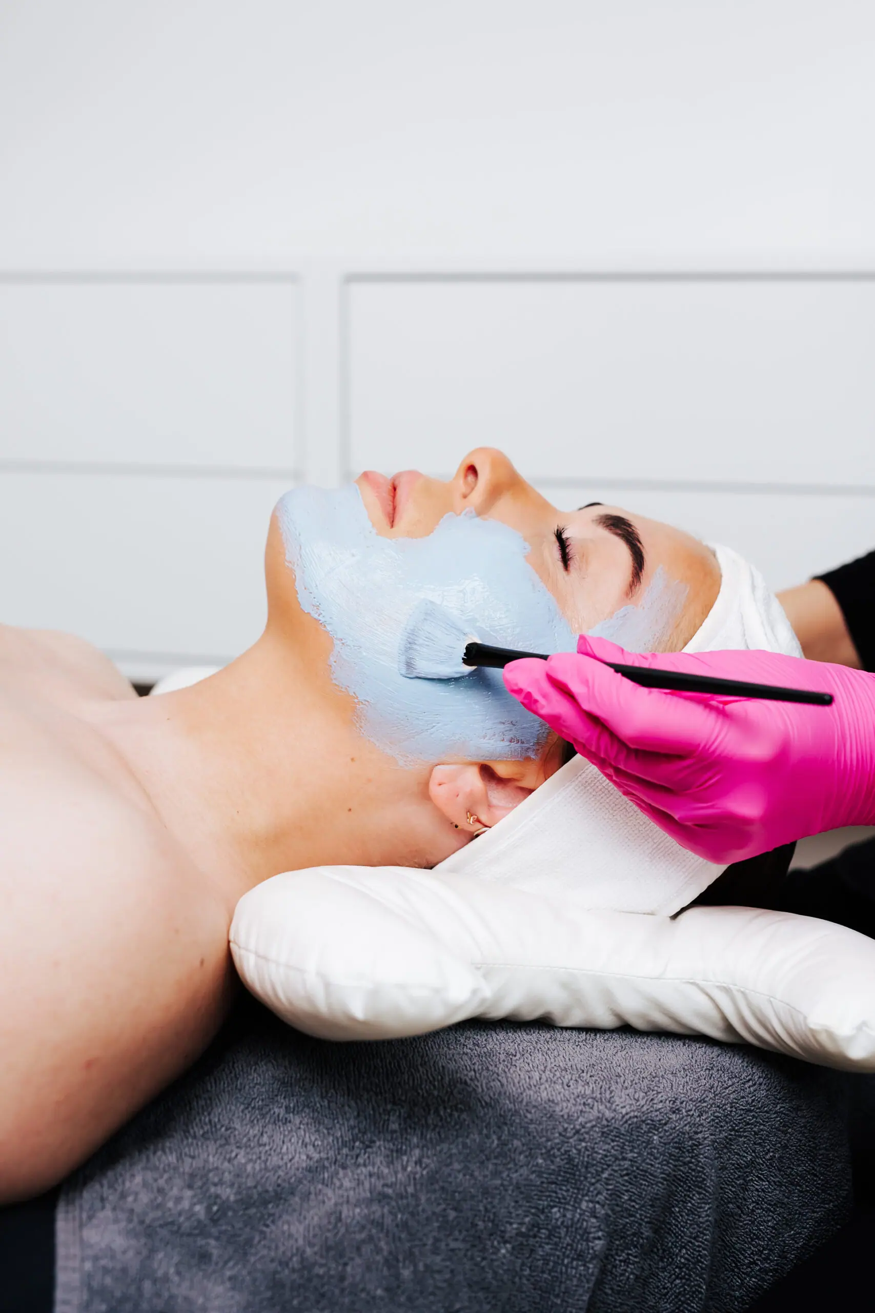 En blå maske lægges på ansigtet med pensel hos MediSkin